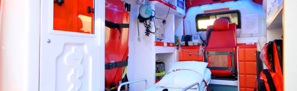 Interior de una ambulancia con camilla, asiento y equipamiento sanitario